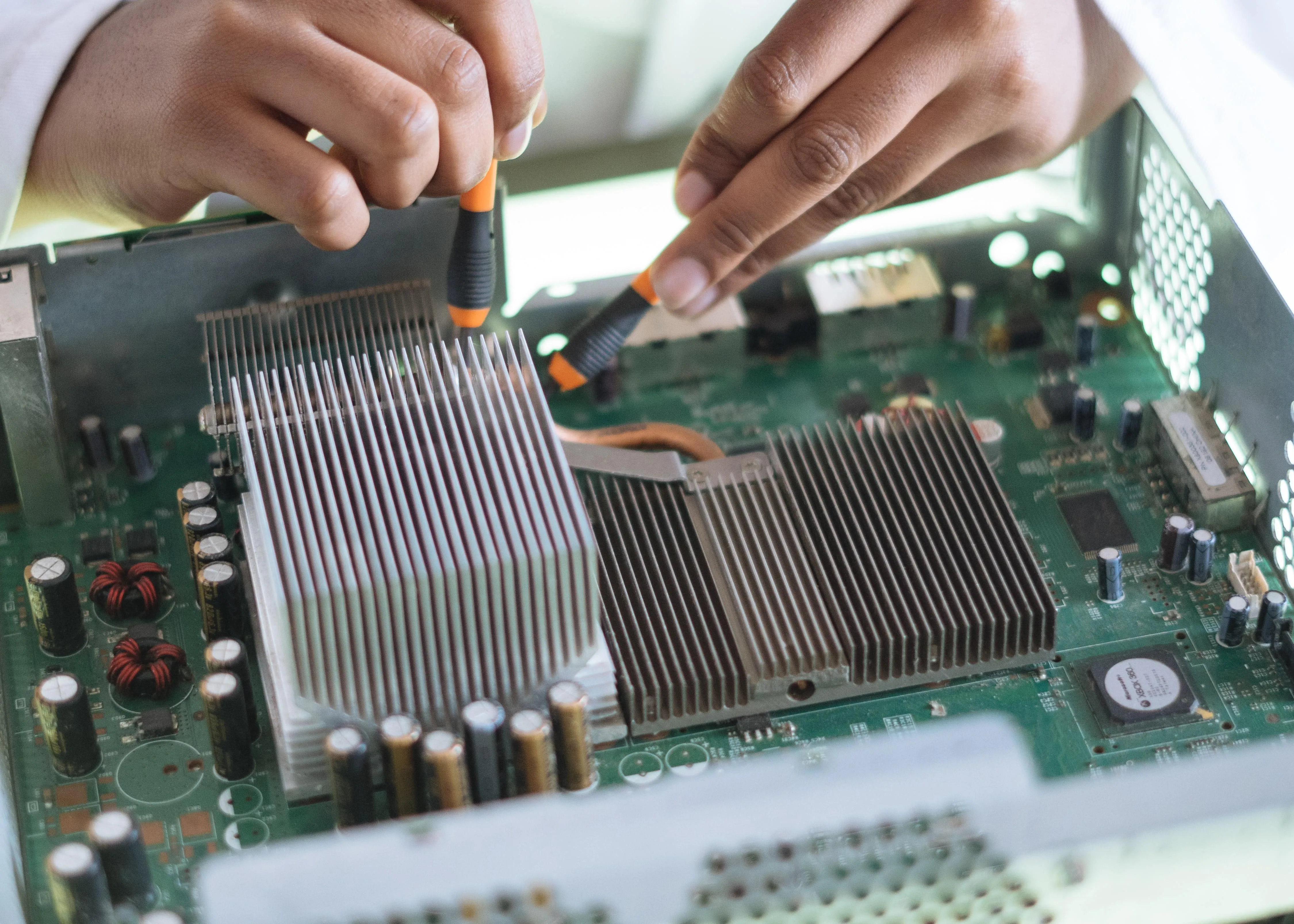 A Simgen technician's hands working precisely on hardware with fine tools